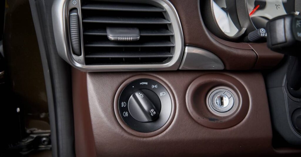 A closeup of a car's external ignition system. The keyhole, air conditioning controls, and vents are visible.