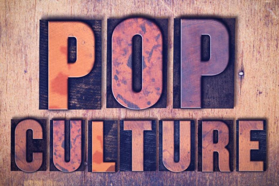 Individual letters spell the phrase "pop culture." The letters sit on a dark backdrop against a wooden surface.