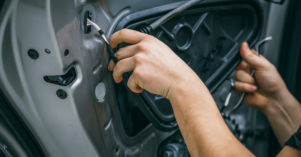 A person disassembling a car door by pulling out a irregularly-shaped component that fits into the center of the interior.
