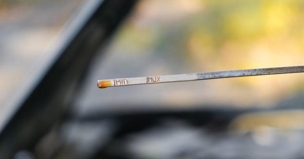 A close-up of a test stick for fluids for a vehicle, with small lettering that reads "min" and "max."